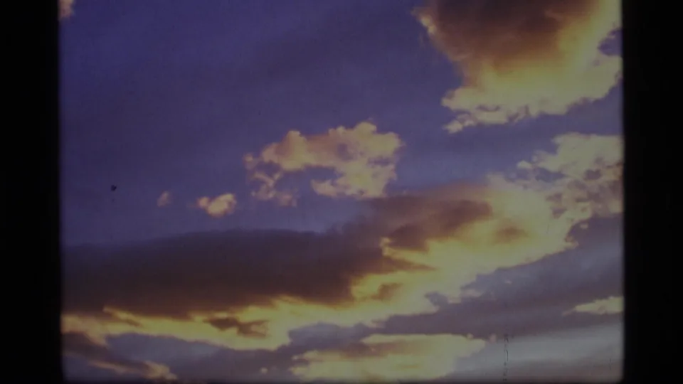1977 Alaska 8mm view of saturated sunset clouds over a barely visible dark horizon.