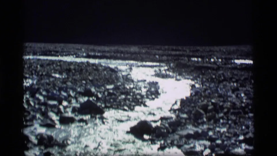 1977 Alaska home-movie view of reflective stream water crossing a rocky gravel bed.