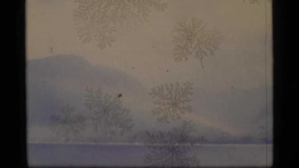 1977 Alaska 8mm view of distant mountains and a faint shoreline, partly obscured by frost-like surface patterns.