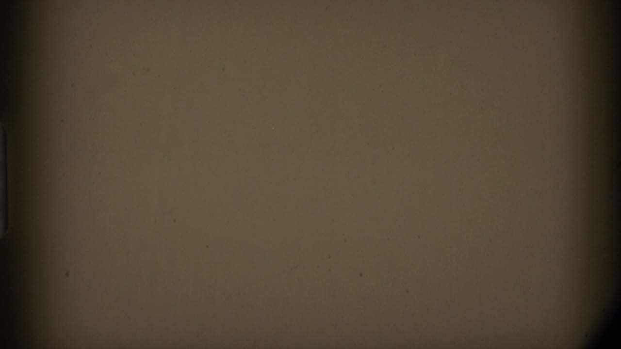 Mostly dark and tan film frame with gate edges and no clear subject visible.