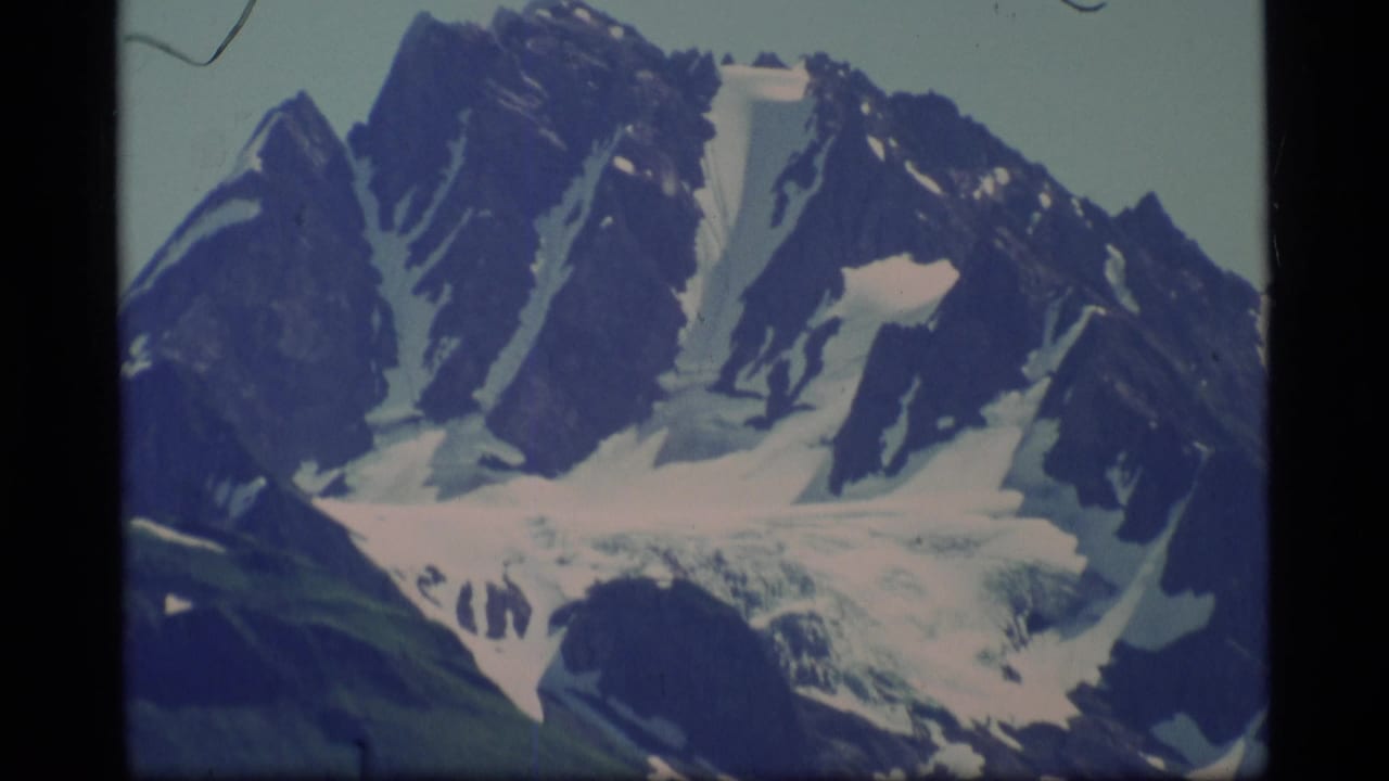 Jagged snow-covered mountain peaks with a glacier beneath them.