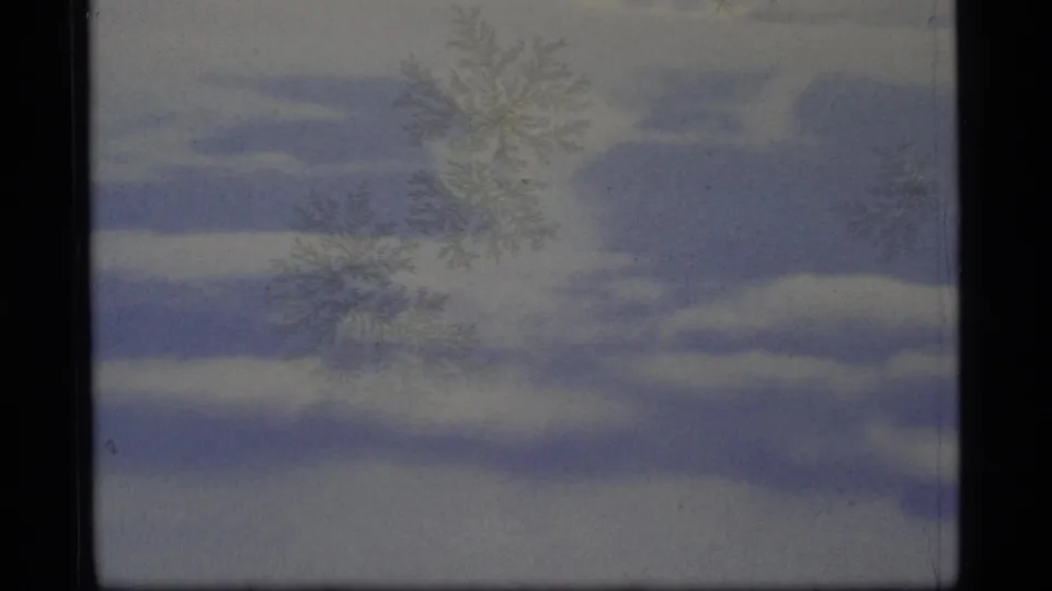 1977 Alaska 8mm frame with layered blue cloud bands, pale overcast sky, gate edges, and faint frost-like film marks.