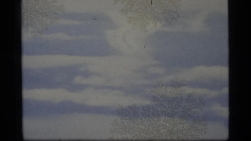 1977 Alaska 8mm frame showing muted blue-white cloud streaks, pale sky, grain, and slight color fading.