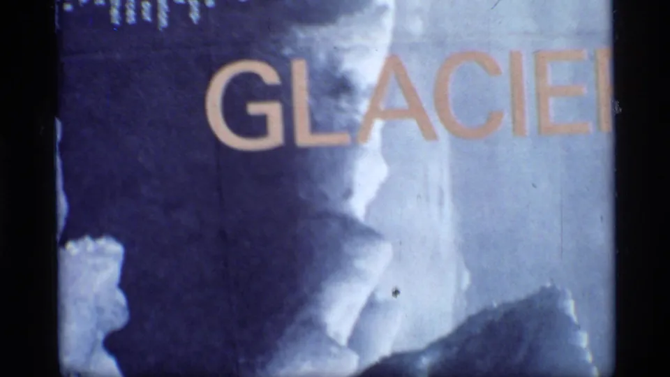 1977 Glacier Bay 8mm frame showing bold GLACIER lettering across a blue-white glacier title card with analog specks.