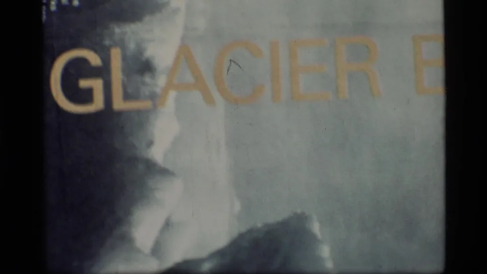 Glacier Bay sign detail in 1977 8mm footage, with yellow GLACIER lettering and visible film wear.
