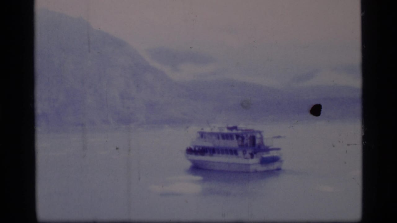 Ferry farther across the bay with mountains and a dark film mark nearby.