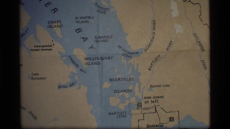 1977 8mm frame showing a closer Glacier Bay, Alaska map view with Drake Island, Willoughby Island, Beardslee Islands, and Bartlett Cove.