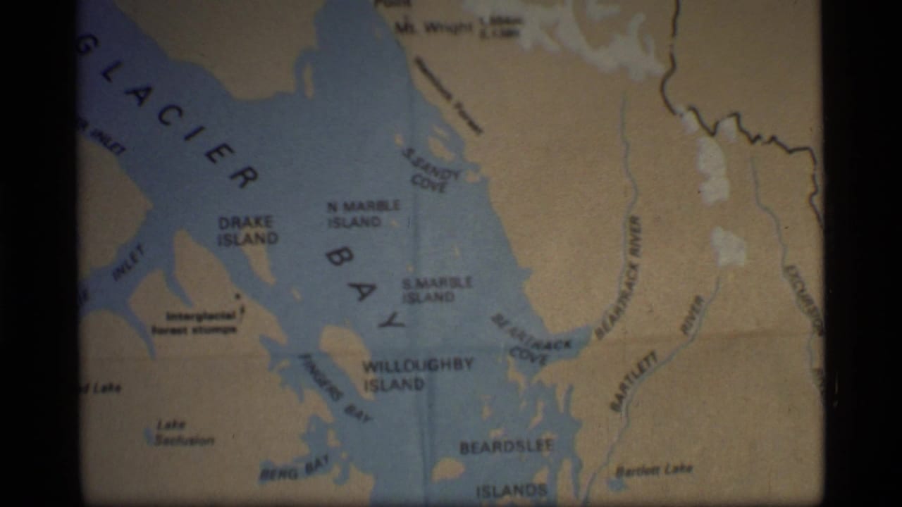 1977 8mm frame of a folded Glacier Bay, Alaska map with island, cove, bay, and inlet labels visible.