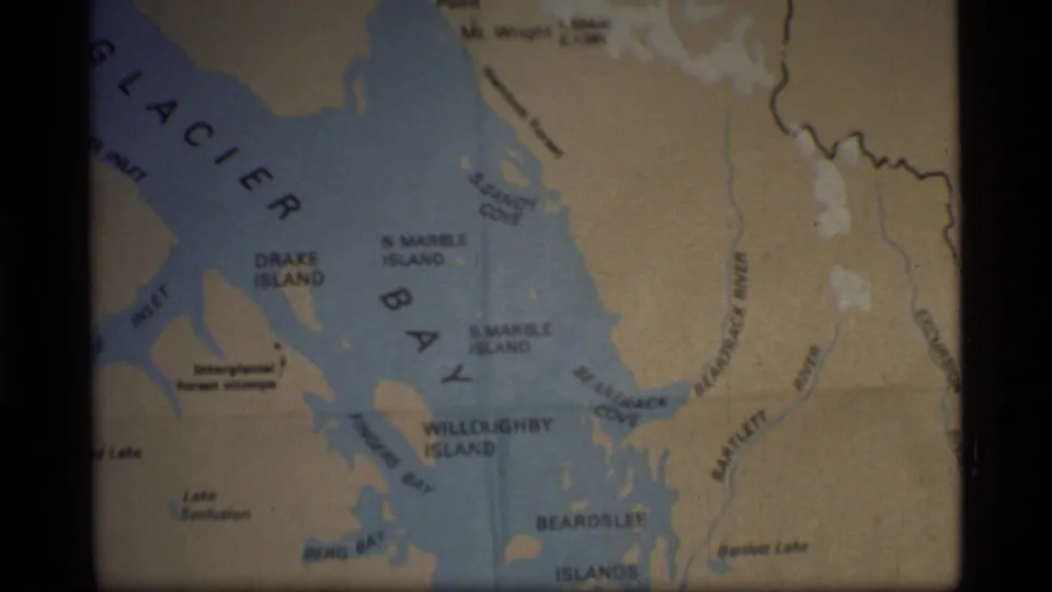 1977 8mm frame of a folded Glacier Bay, Alaska map with island, cove, bay, and inlet labels visible.