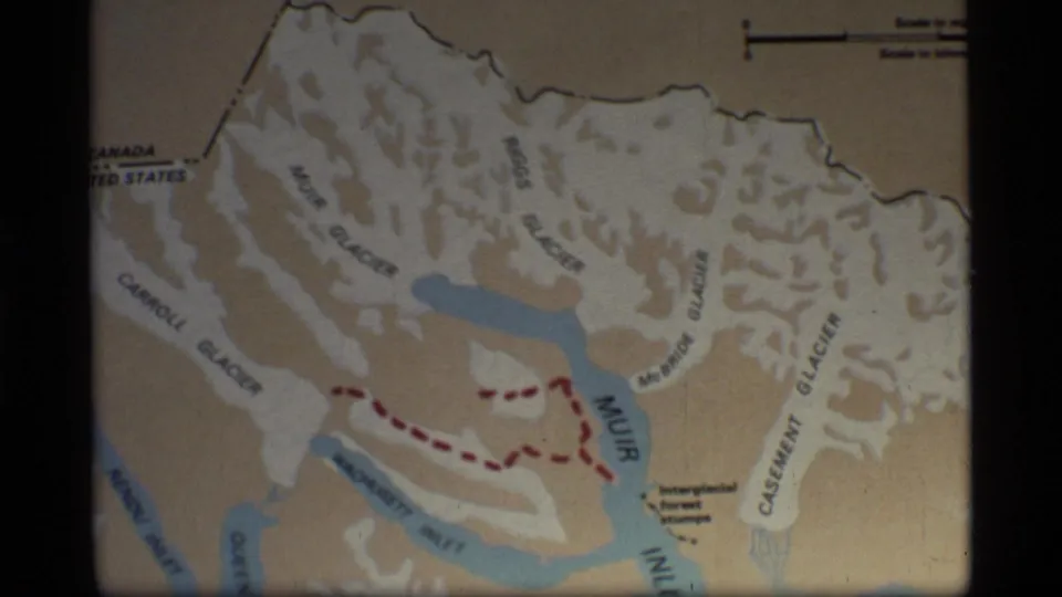 1977 Glacier Bay, Alaska map view with Muir Glacier, Muir Inlet, blue waterways, and a red dashed route visible on aged 8mm film.