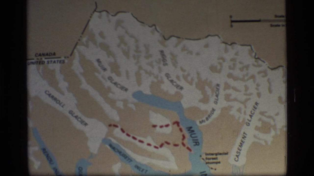 1977 Glacier Bay, Alaska 8mm frame showing a printed map with glacier labels, blue waterways, and a red dashed travel route.