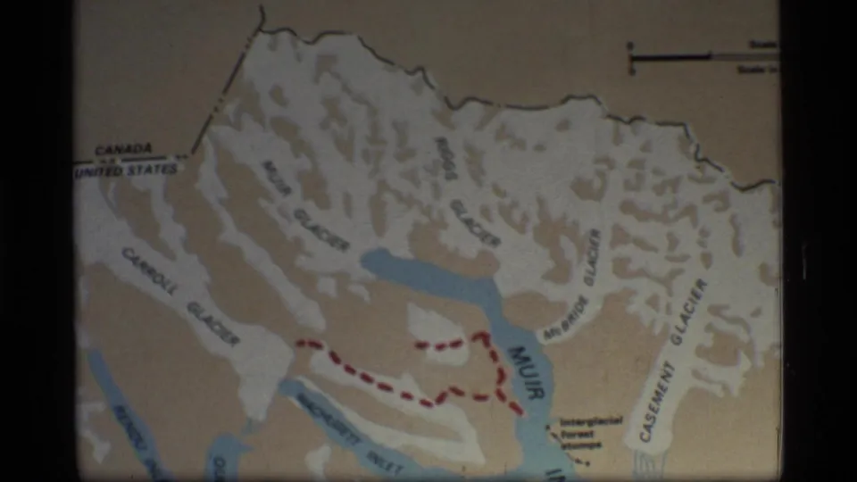 1977 Glacier Bay, Alaska 8mm frame showing a printed map with glacier labels, blue waterways, and a red dashed travel route.
