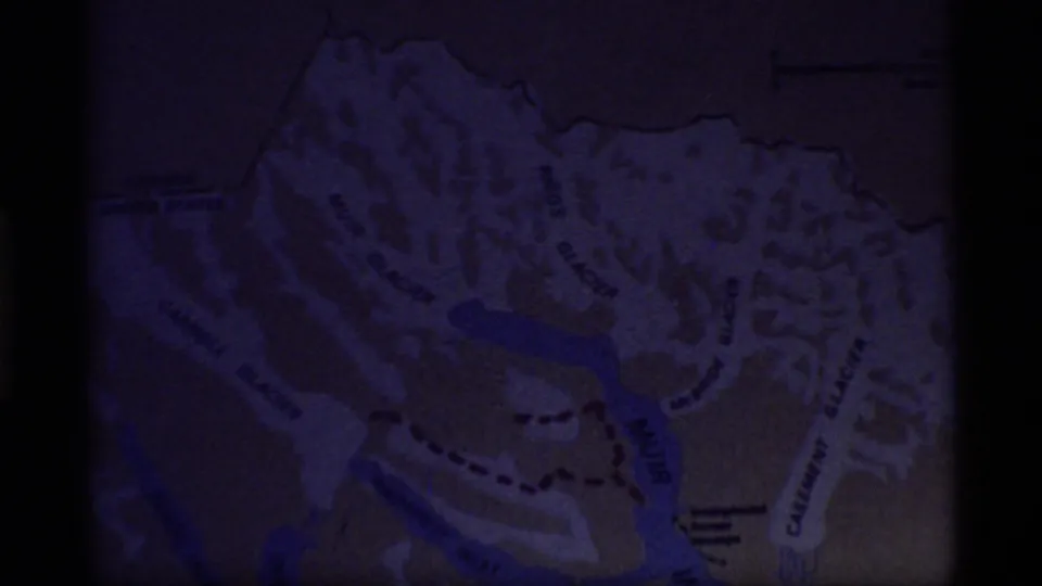 Final 1977 Glacier Bay map frame fading darker, with glacier labels and the red route still faintly visible.