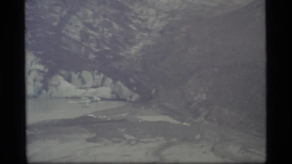 Glacier Bay, Alaska, seen in faded 1977 8mm footage with icy shoreline, water, and rugged mountainside.
