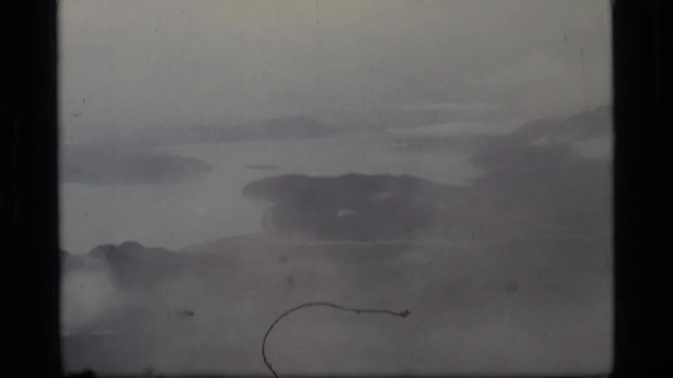 Glacier Bay 1977 8mm frame showing misty water, distant dark terrain, and visible film wear near the lower right.