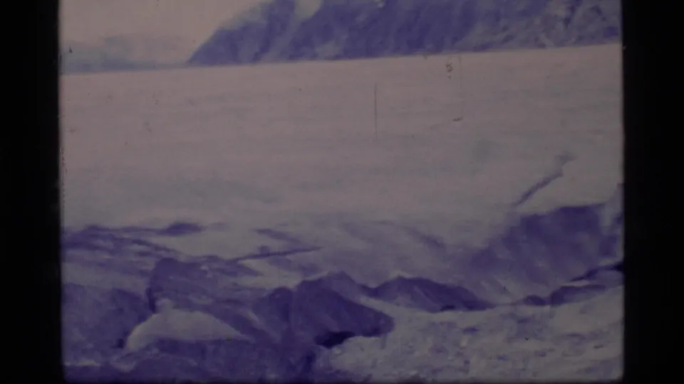 A wide Glacier Bay 8mm view shows broken ice, low snow ridges, and distant mountain slopes with no close human detail visible.
