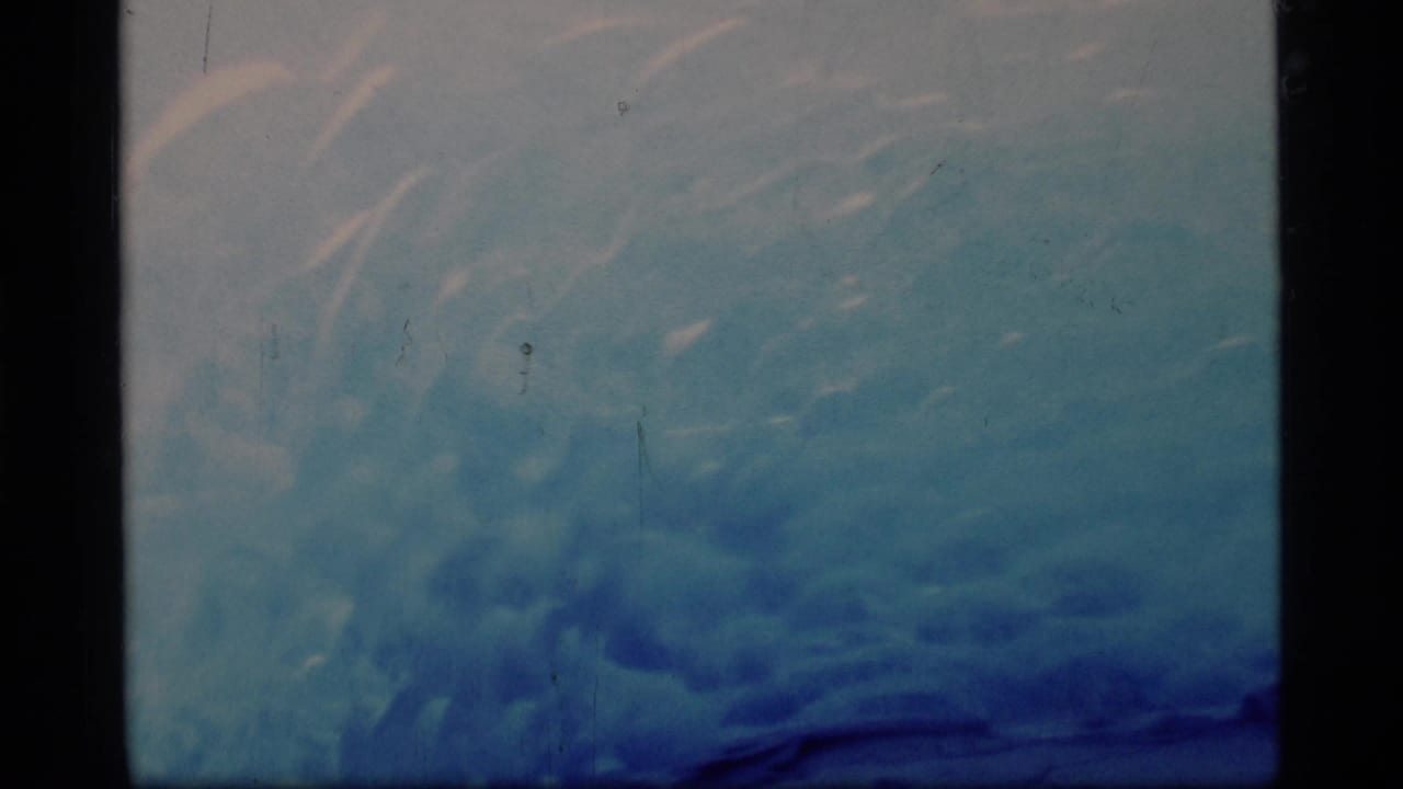 Close view of blue glacier ice framed by dark 8mm film borders.