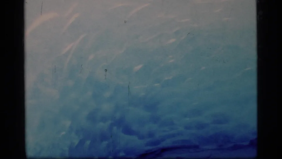1977 8mm frame from Glacier Bay showing textured blue glacier ice with soft exposure and visible film grain.