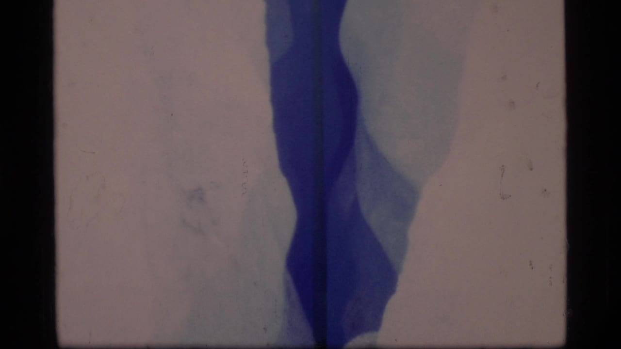 Close view of a deep blue crack or crevasse in ice with dark film borders.
