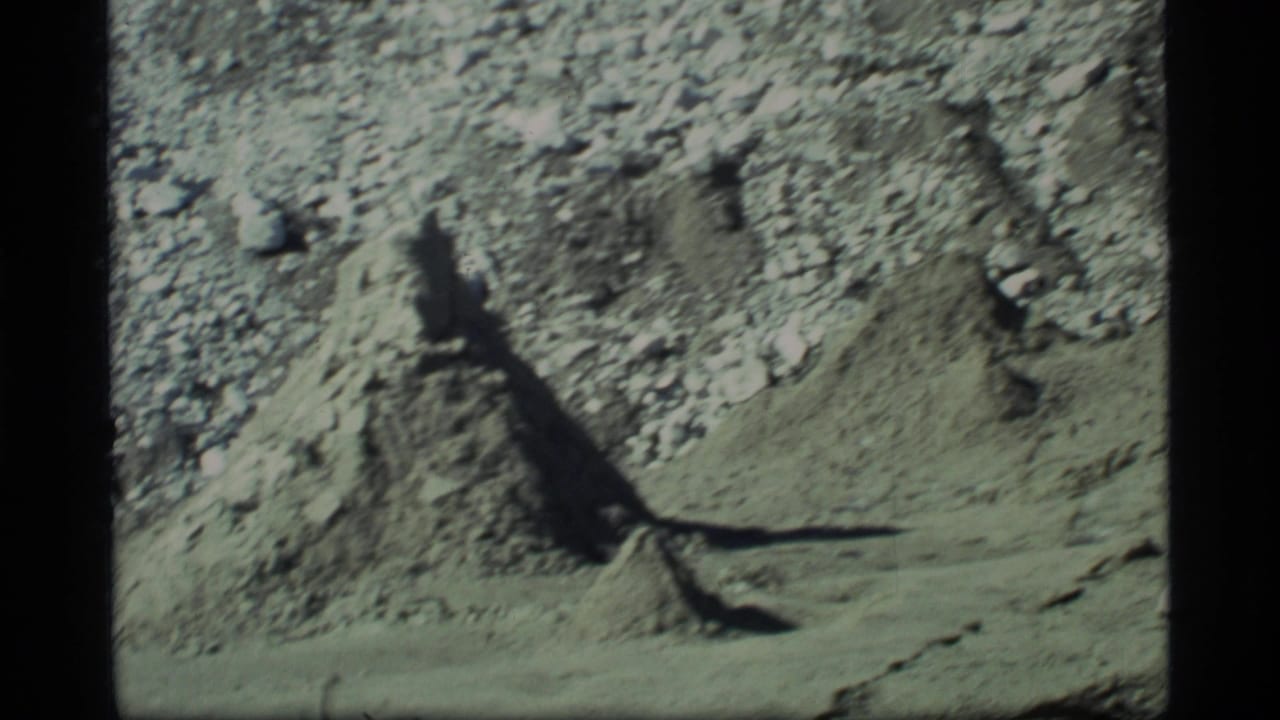 Rocky dirt slope with a dark shadow across barren ground.