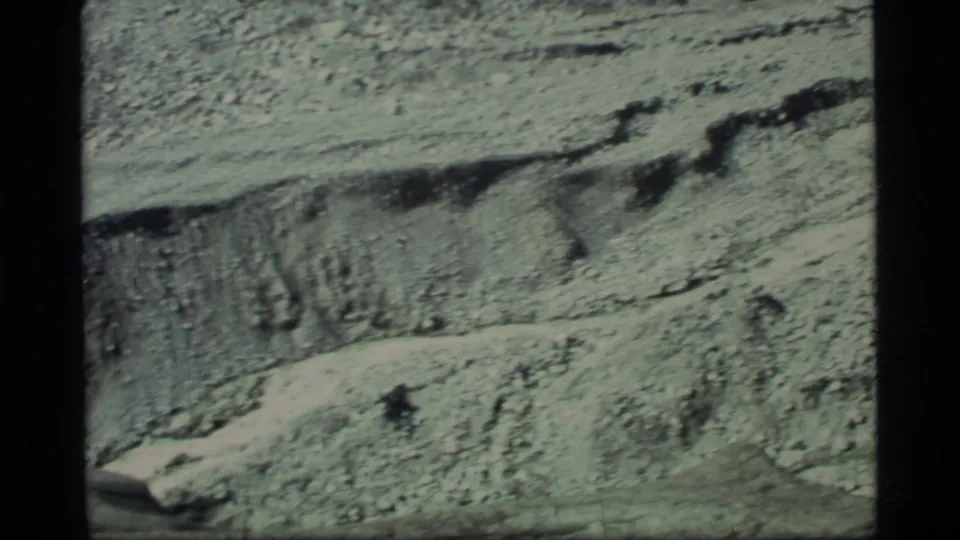 1977 Glacier Bay 8mm view of pale eroded mountain surface with darker streaks and rough geological texture.