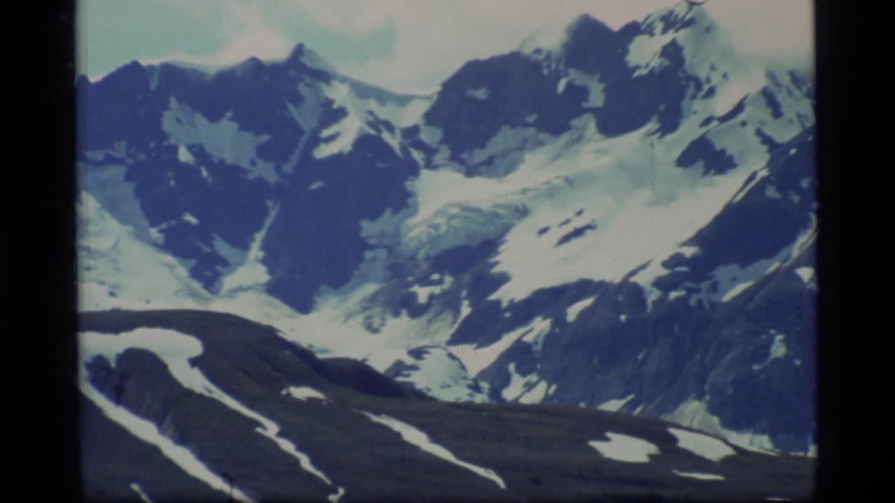 Distant snowy mountains with dark ridges and patches of ice or snow.