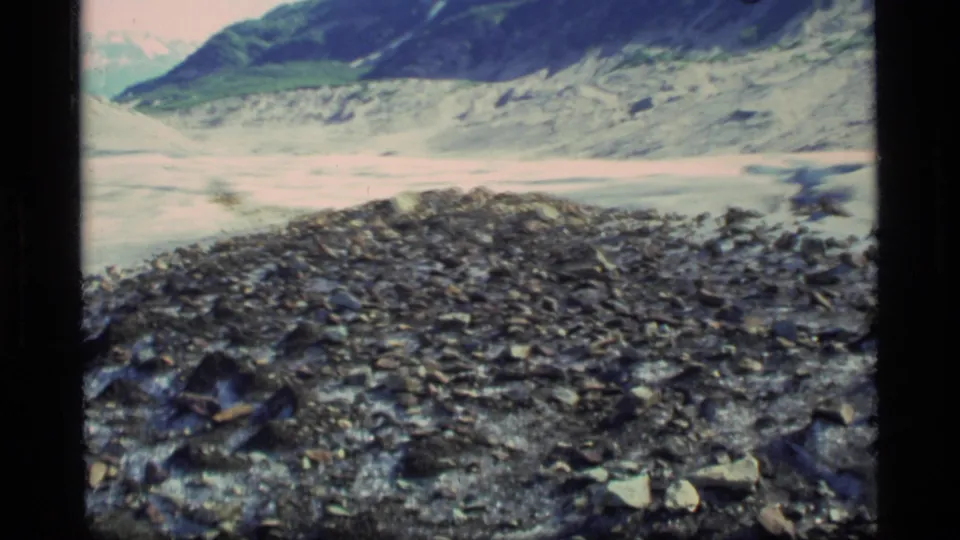 A final Glacier Bay view shows rough moraine stones before pale glacier ice and dark mountains.