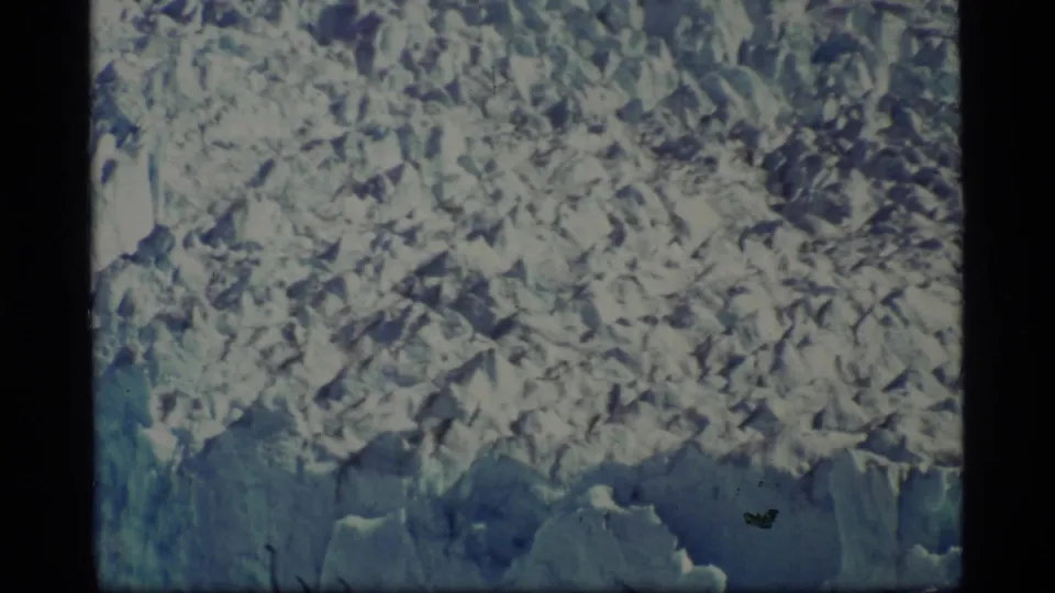 Close 1977 8mm view of jagged Glacier Bay ice formations with blue shadows and dense snow texture.