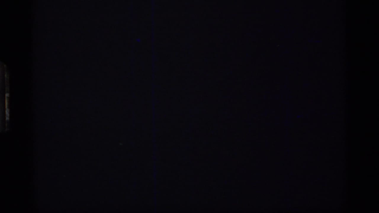 Dark 1977 8mm frame from the Glacier Bay reel with only faint film edges and exposure texture visible.