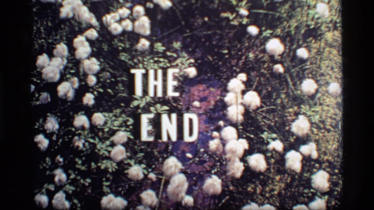 White THE END title card surrounded by pale flowers and leafy greenery.