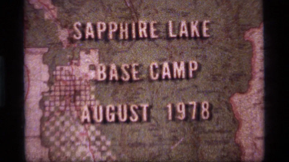 Close 8mm frame from the Sapphire Lake clip with Base Camp and August 1978 text centered on a faded map background.