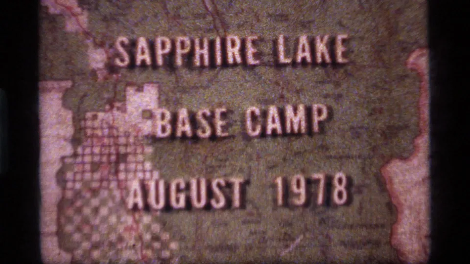 1970s 8mm title card for Sapphire Lake Base Camp in Montana, with August 1978 lettering over a textured map-like background.