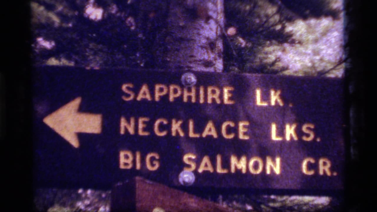 Dark wooden trail sign pointing left to Sapphire Lake, Necklace Lakes and Big Salmon Creek.
