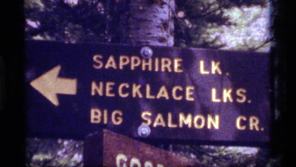 1977 Montana 8mm close-up of a woodland trail sign for Sapphire Lake, Necklace Lakes and Big Salmon Creek.