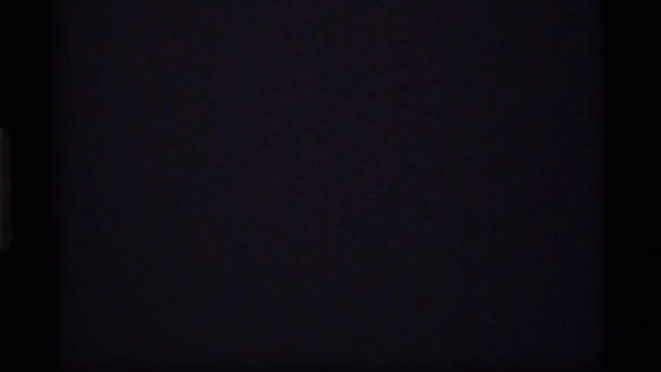 End frame fades into near-black 8mm exposure with faint purple grain and little visible scene detail.