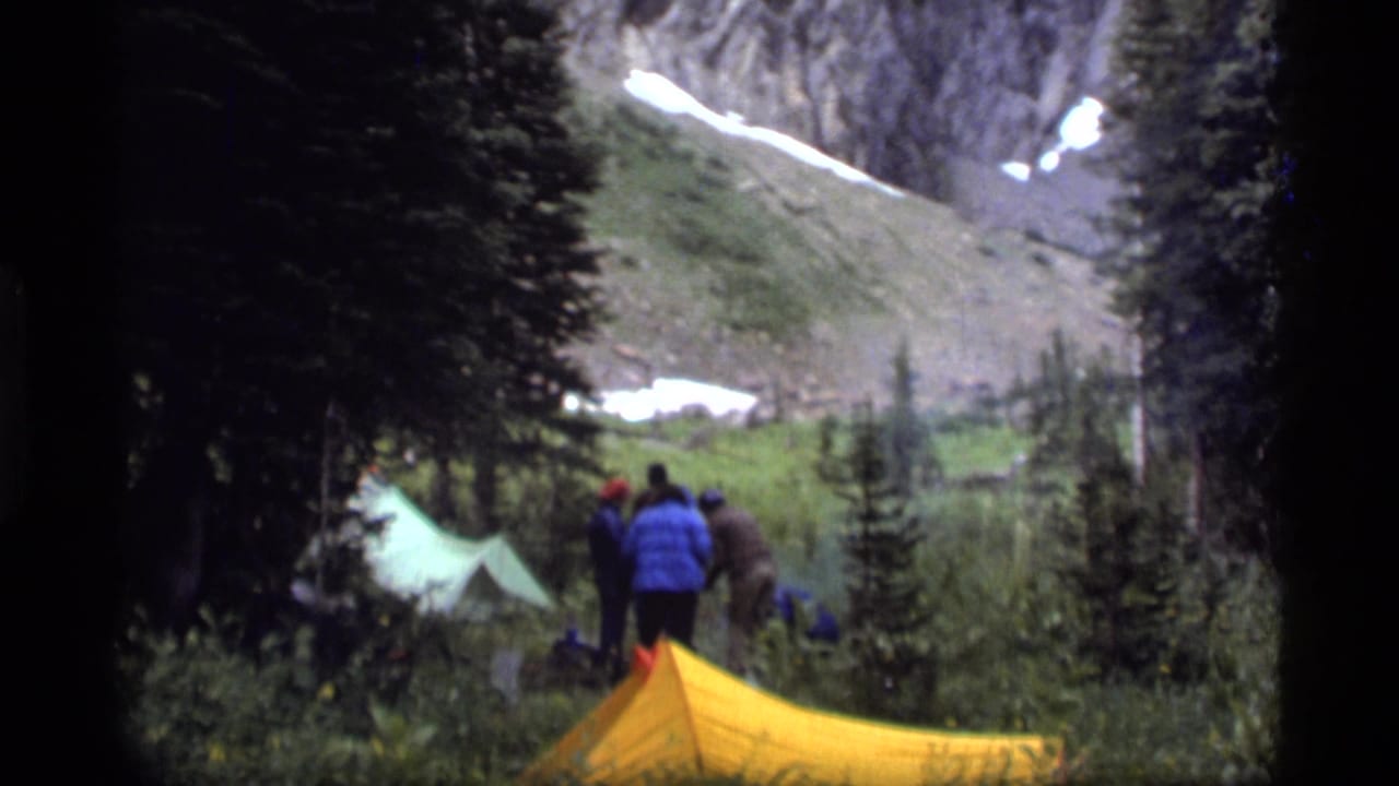 Campers at Sapphire Lake, Montana, appear to set up or adjust gear beside tents in a 1977 8mm home-movie frame.