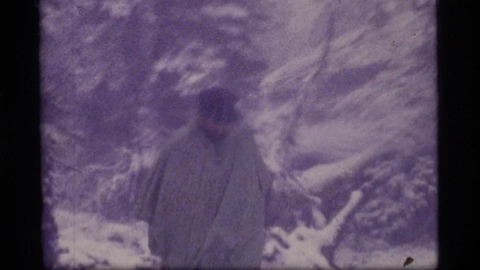 A closer, softly exposed frame shows the bundled adult near snow-laden branches in the Montana winter woods.