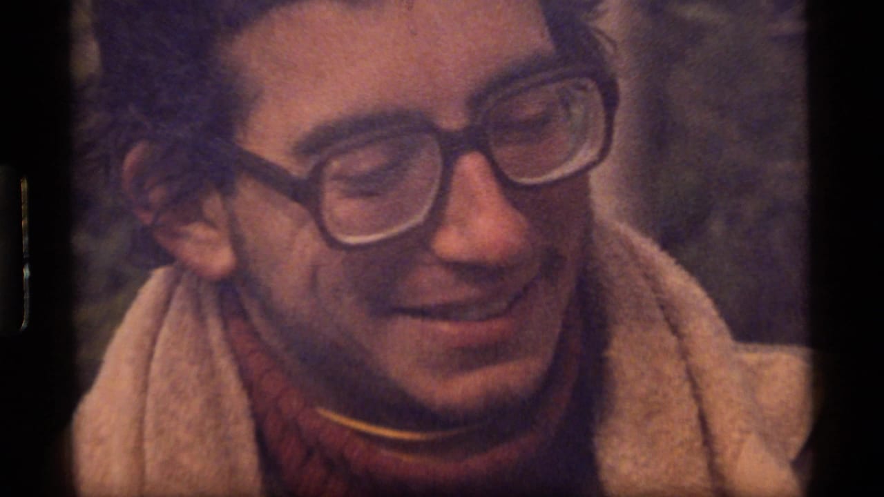 Soft 1977 8mm close-up of a smiling man with thick-rimmed glasses at Sapphire Lake, Montana.