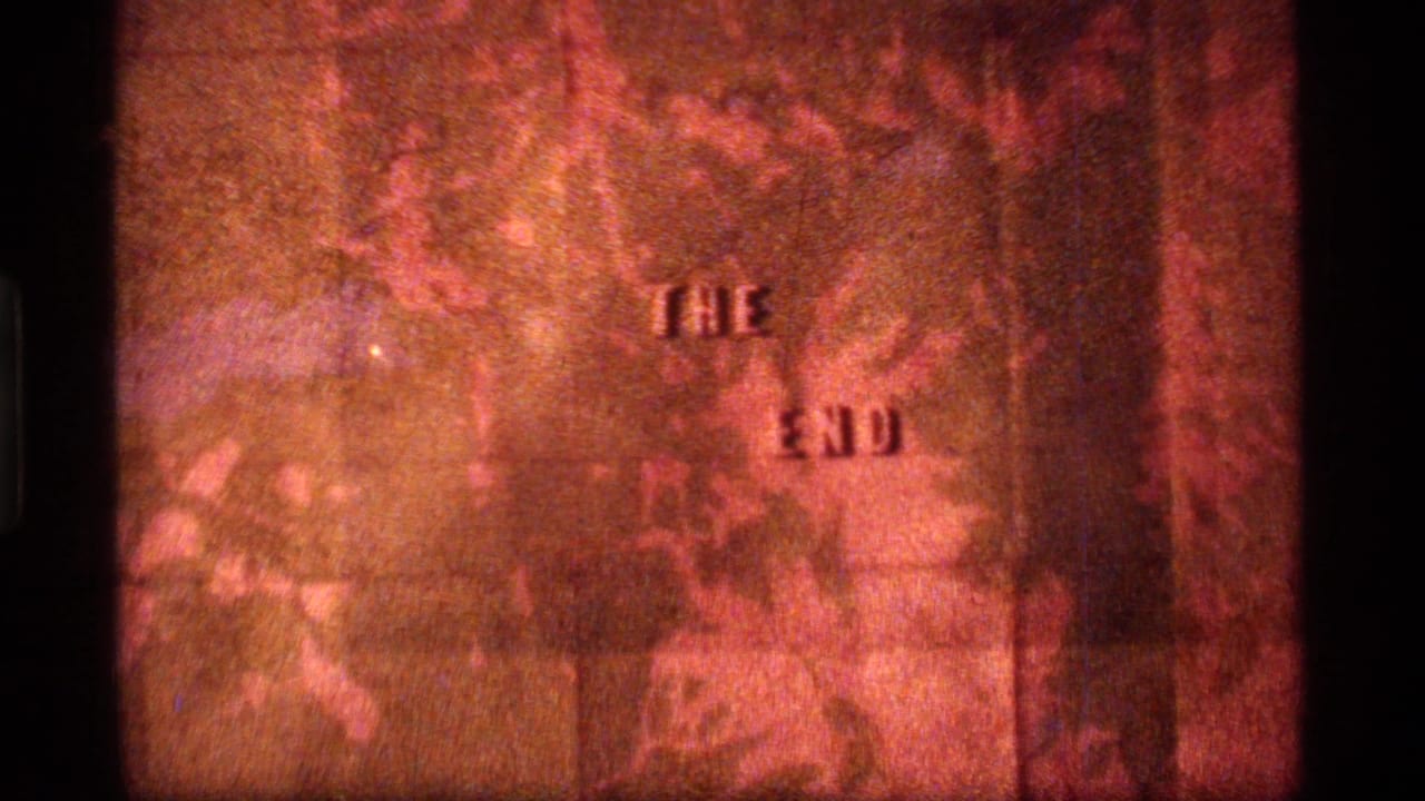 1977 8mm home-movie end card from Sapphire Lake, Montana, showing "THE END" against a warm orange textured field.
