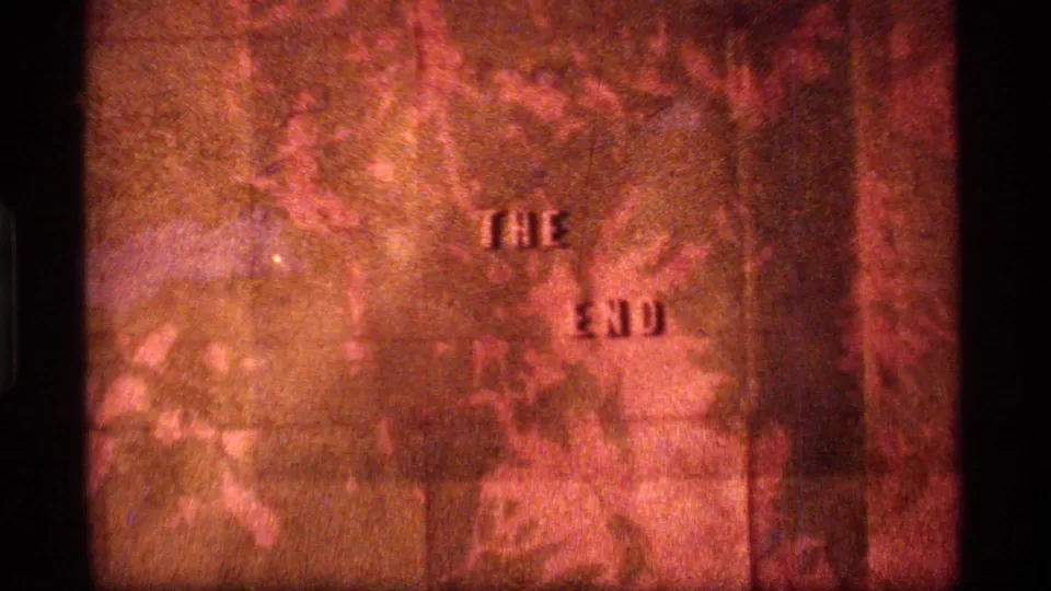 1977 8mm home-movie end card from Sapphire Lake, Montana, showing "THE END" against a warm orange textured field.