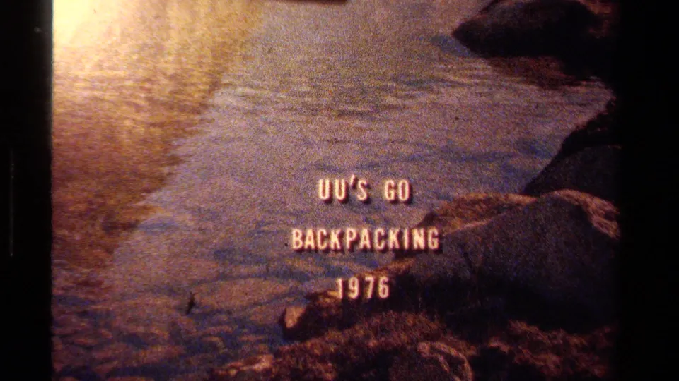 1970s Lake Tahoe frame showing the backpacking title over softly focused water, rocks, and warm reflected light.