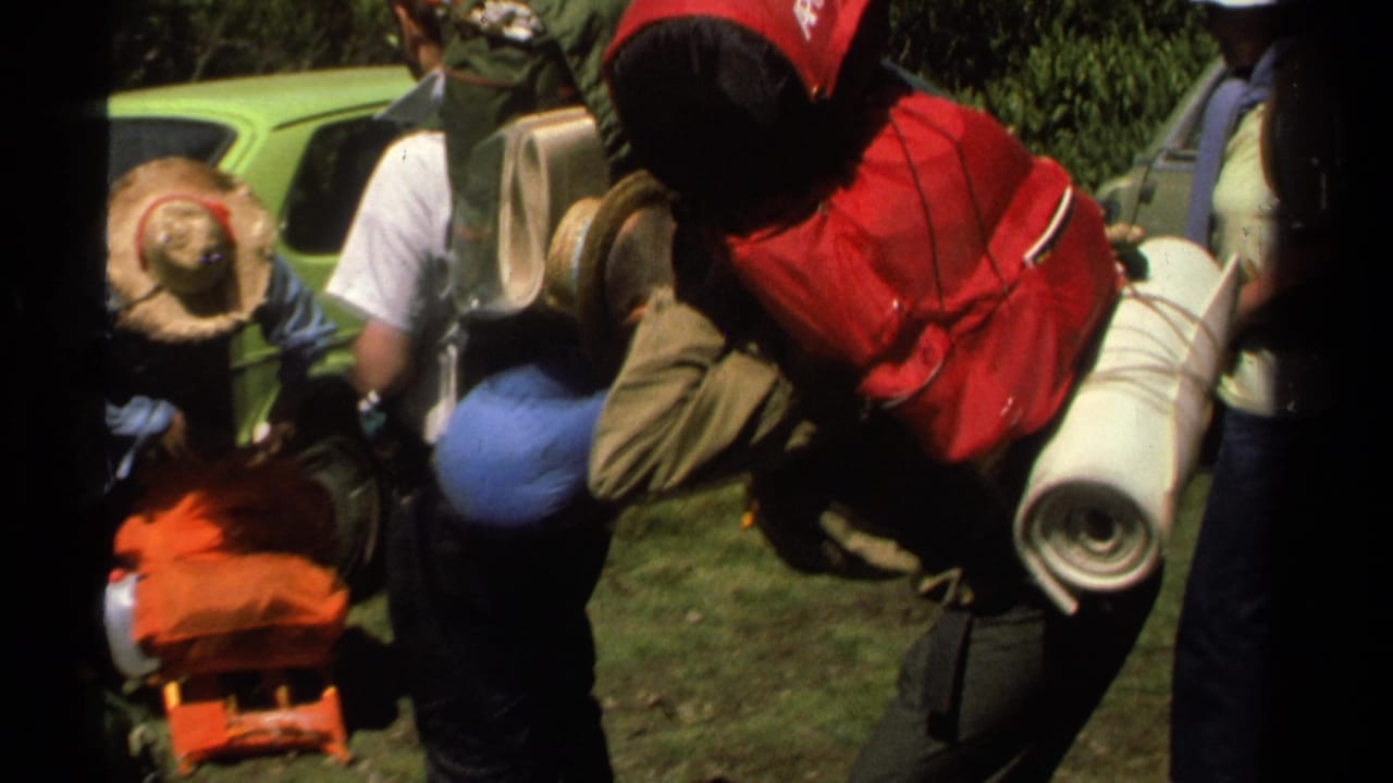 1978 Lake Tahoe frame showing hikers in retro outdoor clothing adjusting loaded backpacks and camping equipment.