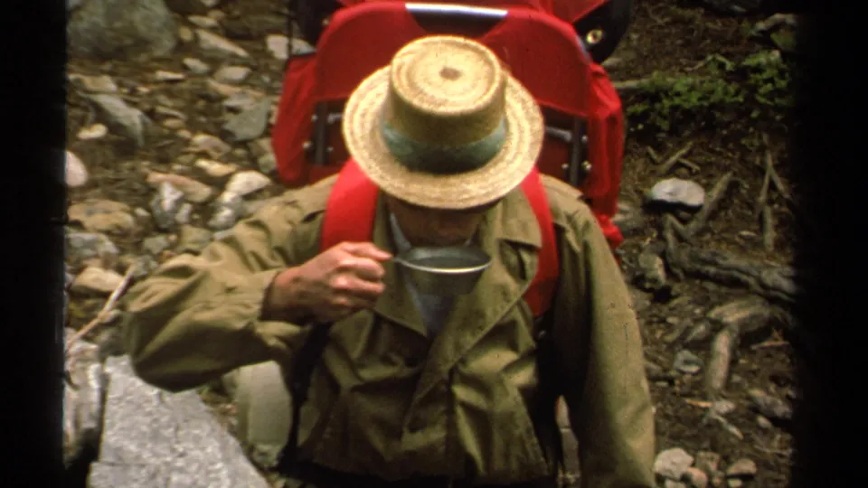 In the Lake Tahoe wilderness scene, the hiker drinks from a metal cup with a red backpack and straw hat visible.