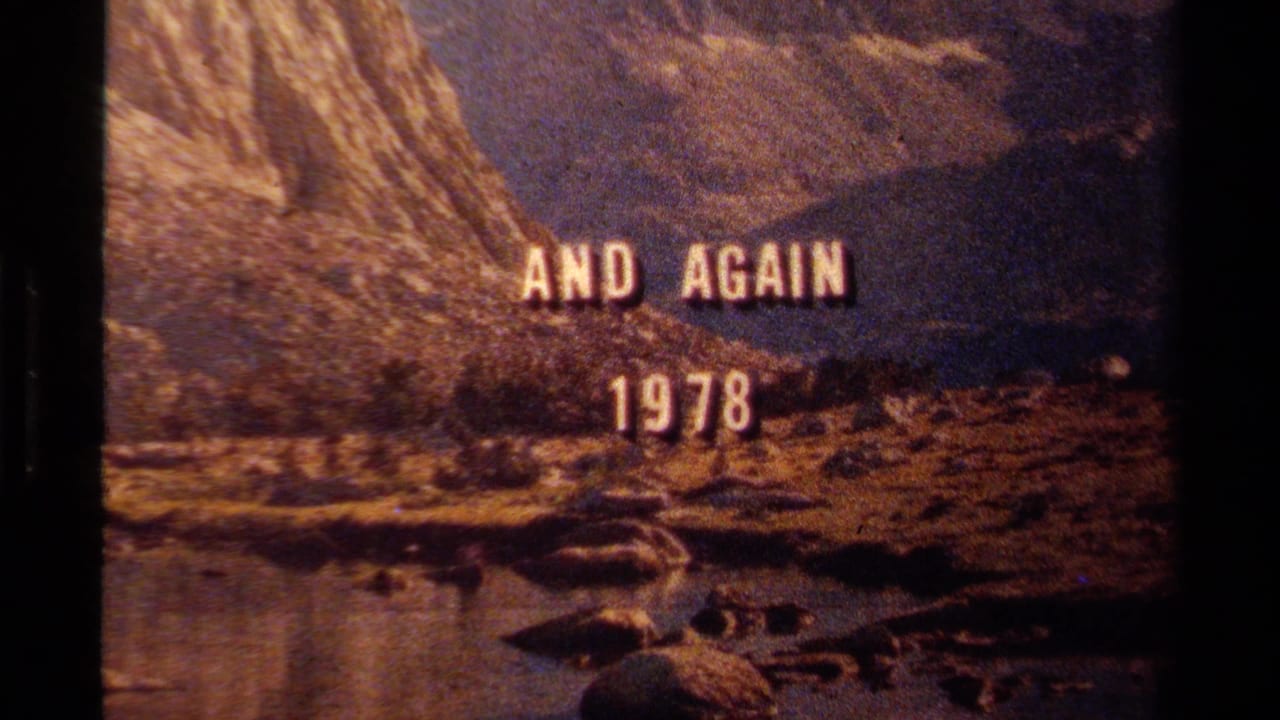 1978 Lake Tahoe home-movie title card reading AND AGAIN 1978 over water, shoreline rocks, and a steep mountainside.