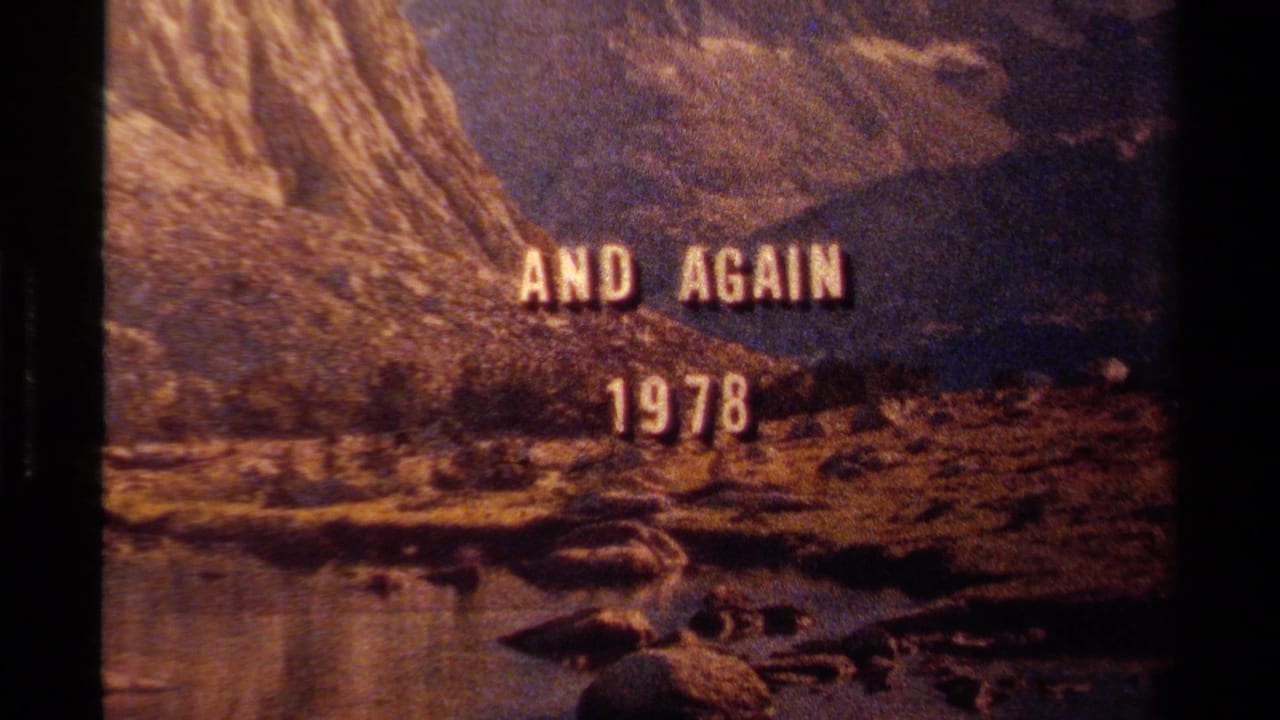 Lake Tahoe title frame with AND AGAIN 1978 centered over a rocky shore, water, and mountain backdrop on 8mm film.