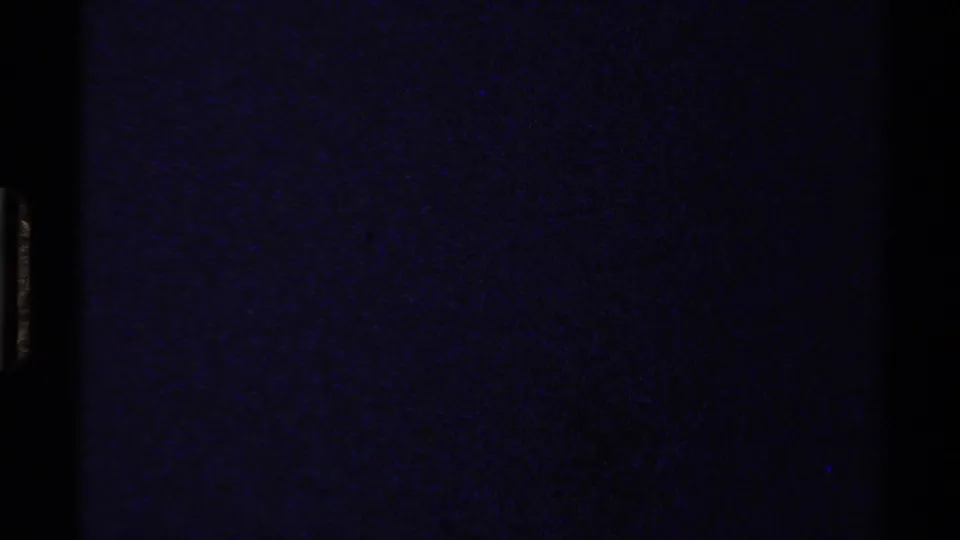 Dark blue-black 8mm transition or leader-like frame with visible grain and no identifiable subject.