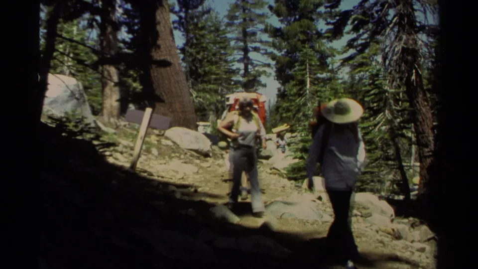 1978 Lake Tahoe 8mm frame showing hikers passing the handheld camera on a sunlit mountain trail.