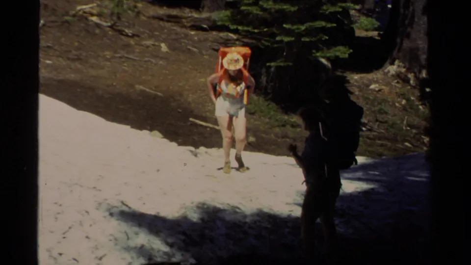 The Lake Tahoe trail scene shows a woman with an orange pack on bright snow and a shadowed backpacker near a dark tree trunk.