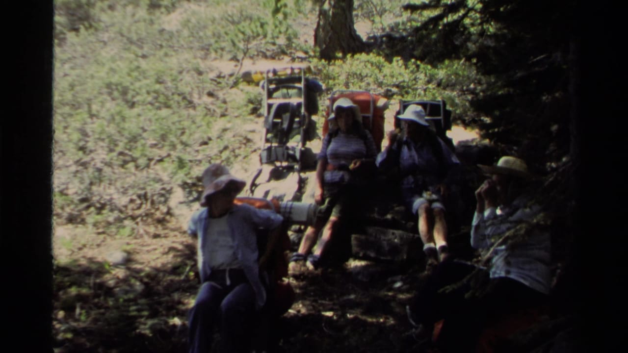 Lake Tahoe 1978 frame with several hikers seated in tree shade beside backpacks and forest trail gear.