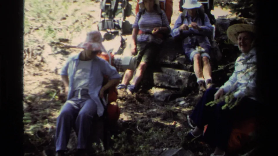 Lake Tahoe 1978 frame of campers in casual hiking clothes resting in shade with backpacks on a wooded trail.